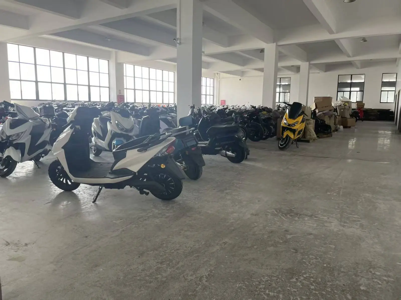 Aitose EV warehouse with rows of finished electric motorcycles ready for export